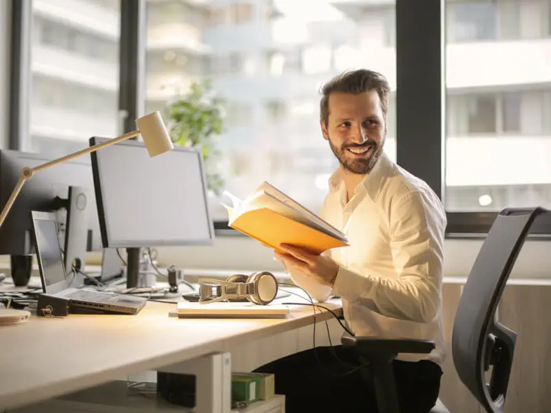 Homme souriant assis à un bureau